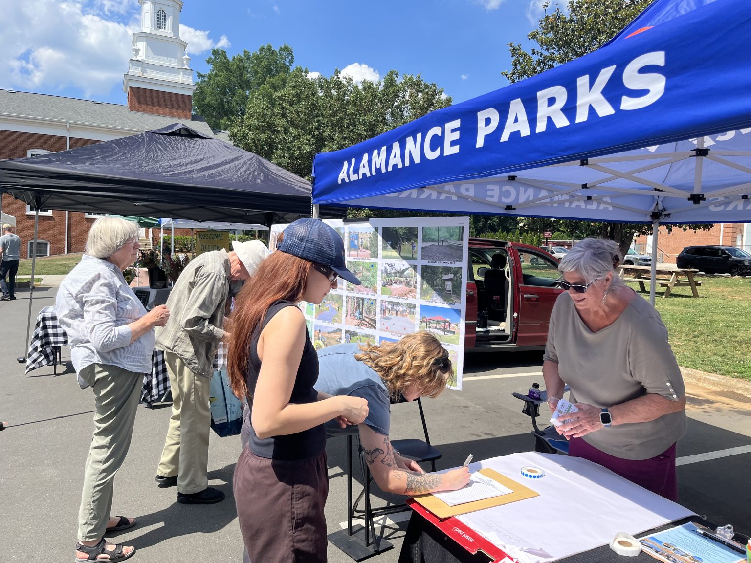Two women viewing park facility options at public engagement booth