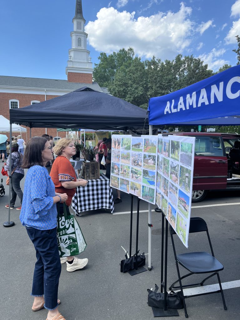 Two women viewing park facility options at public engagement booth